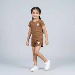Little girl wearing brown cotton t-shirt and matching shorts co-ord set with bow detail casual summer outfit for kids