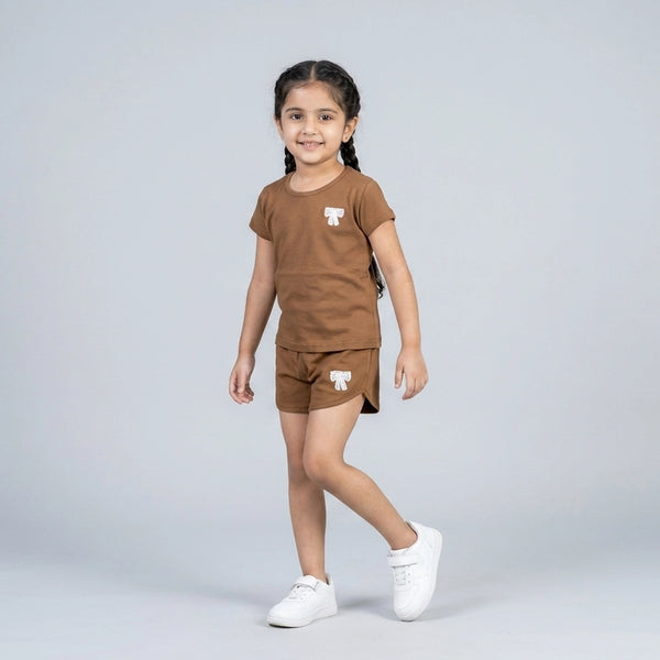 Little girl wearing brown cotton t-shirt and matching shorts co-ord set with bow detail casual summer outfit for kids