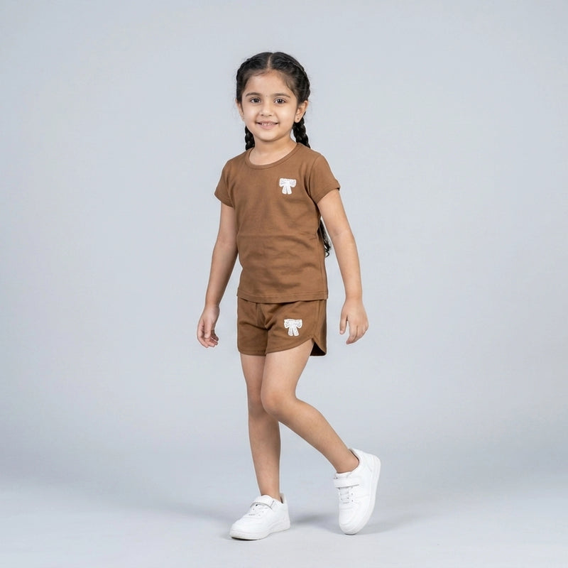 Little girl wearing brown cotton t-shirt and matching shorts co-ord set with bow detail casual summer outfit for kids