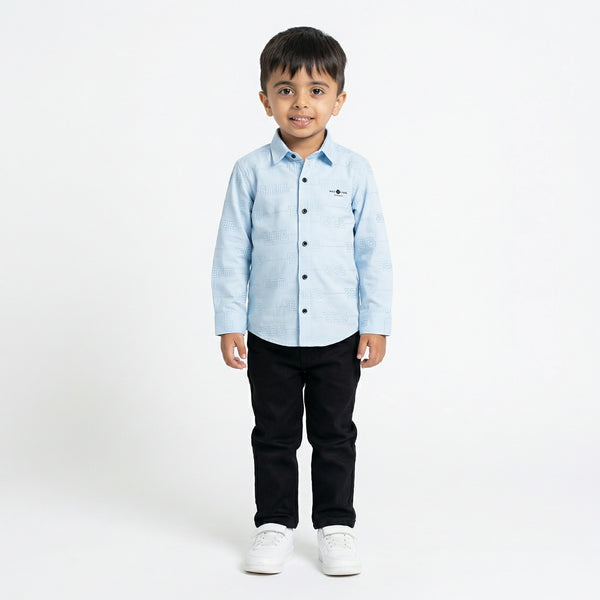 Child wearing a light blue shirt and black pants on a white background
