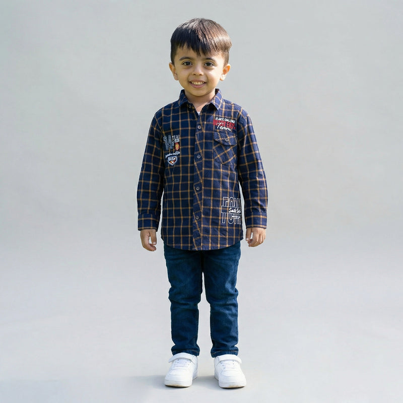 Young boy wearing a Blue checked long-sleeve shirt with dark blue denim jeans and white sneakers against a light studio background