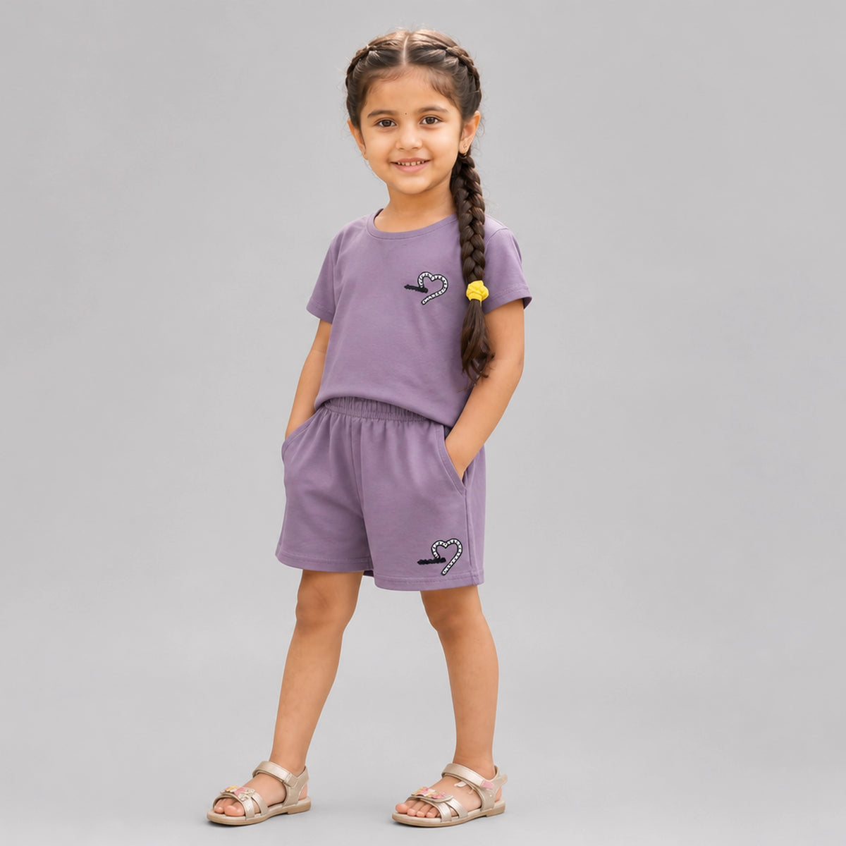 Little girl wearing beige cotton t-shirt and matching shorts co-ord set with heart detail casual summer outfit for kids