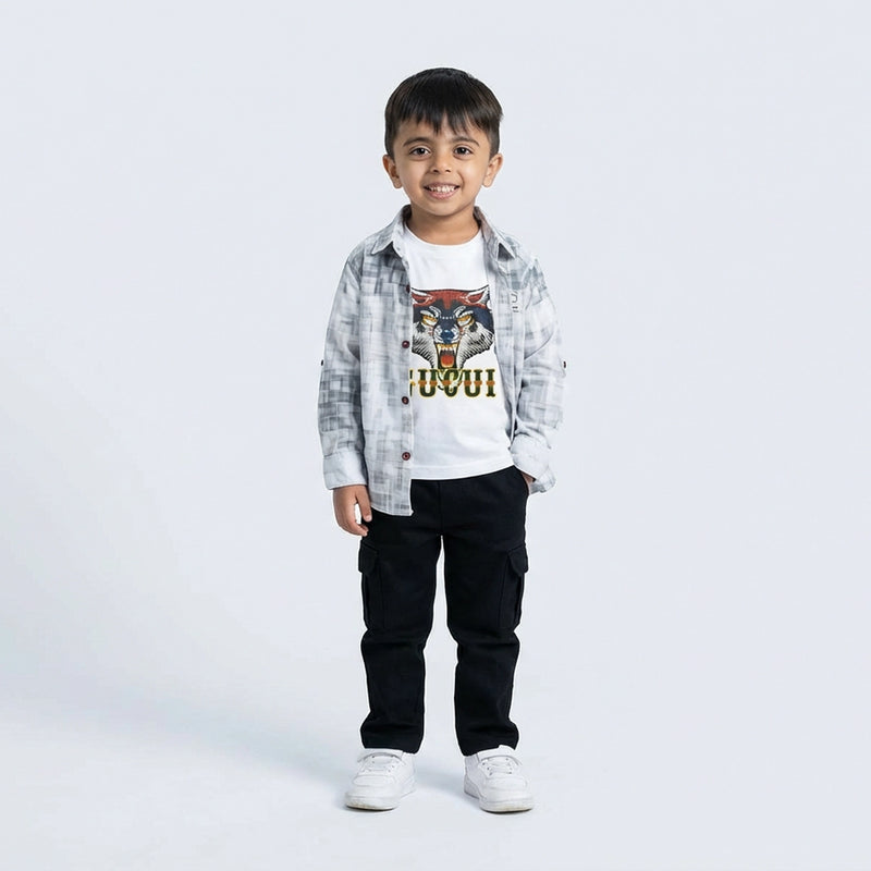 Young boy smiling in a grey check shirt, white tiger graphic T-shirt, black cargo pants, and white sneakers, standing against a plain light background.