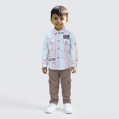 Young boy wearing a pink and white striped casual shirt with sage cargo pants and white sneakers, standing against a plain light background.