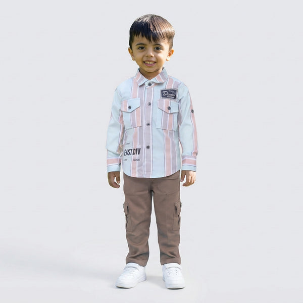 Young boy wearing a pink and white striped casual shirt with sage cargo pants and white sneakers, standing against a plain light background.