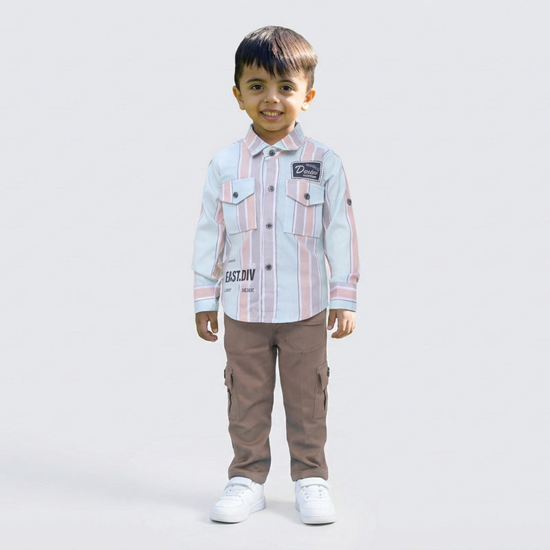 Young boy wearing a pink and white striped casual shirt with sage cargo pants and white sneakers, standing against a plain light background.
