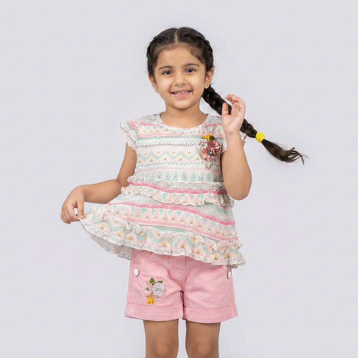 Girl wearing pastel printed ruffle top with pink shorts cute summer outfit for kids stylish casual co-ord set for girls