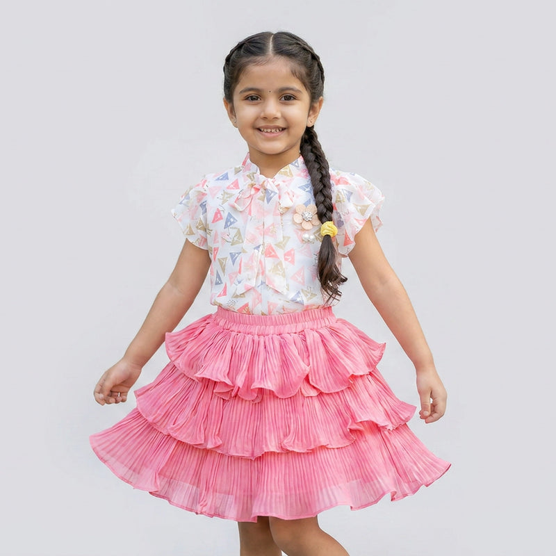 Little girl wearing pink pleated layered skirt with printed flutter sleeve top stylish kids party wear outfit