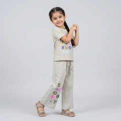Little girl wearing beige Snoopy printed co-ord set with graphic t-shirt and wide-leg pants for kids casual wear