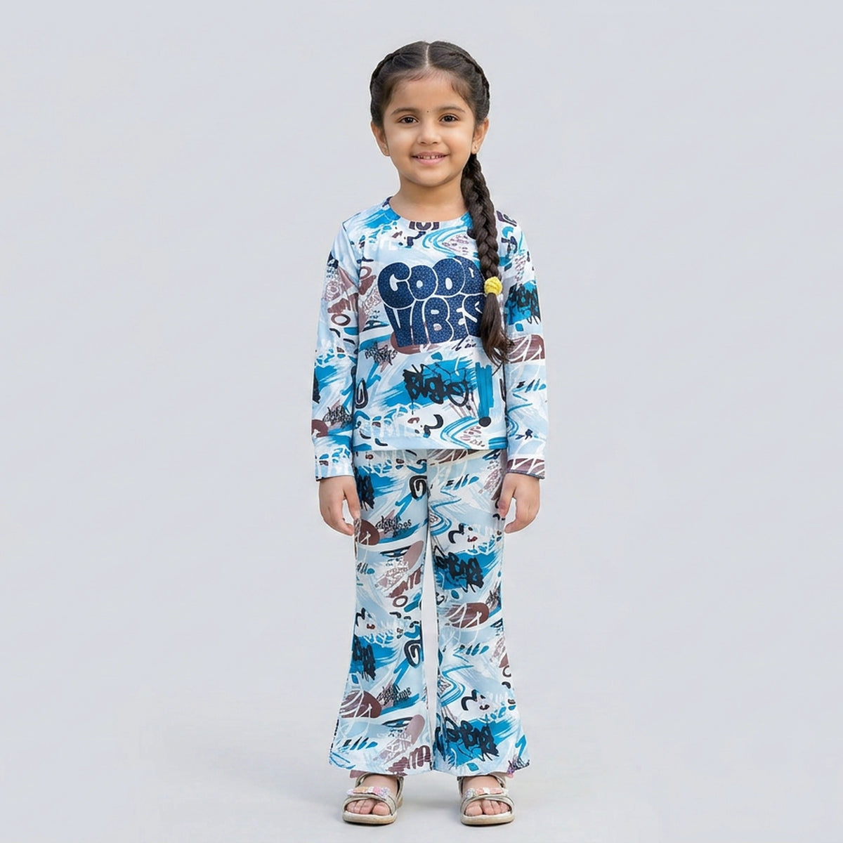 Little girl wearing white and blue graphic printed co-ord set with full sleeve top and matching pants for kids casual wear