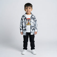 Young boy wearing a black and white printed shirt over a tiger graphic t-shirt with black cargo pants and white sneakers