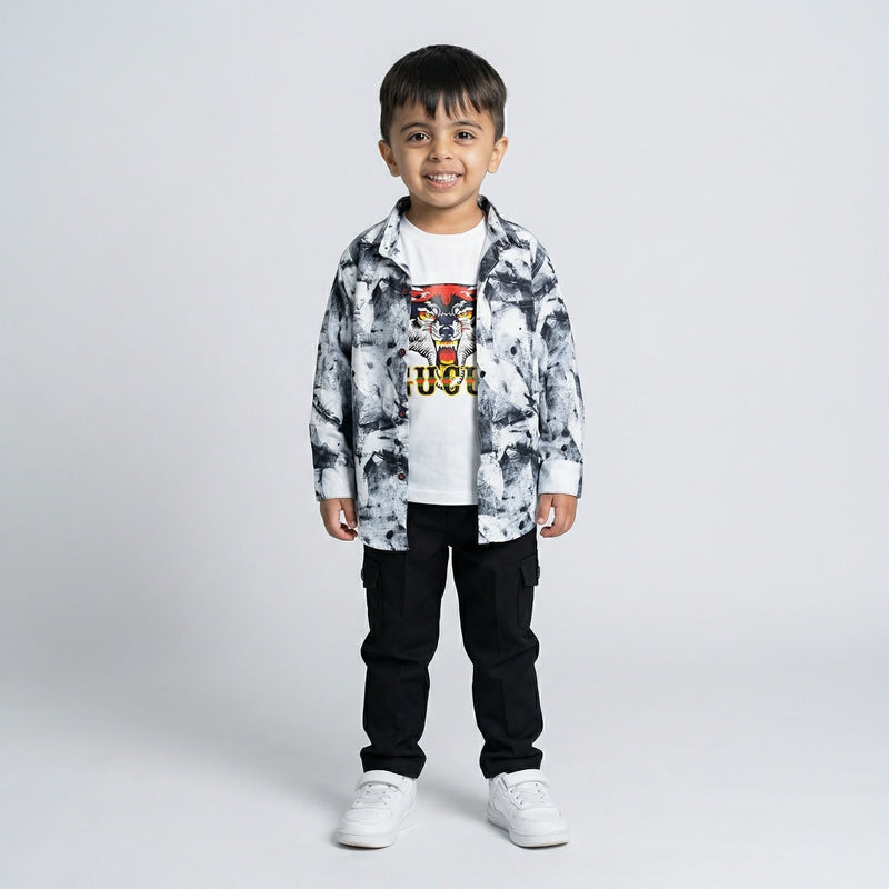 Young boy wearing a black and white printed shirt over a tiger graphic t-shirt with black cargo pants and white sneakers
