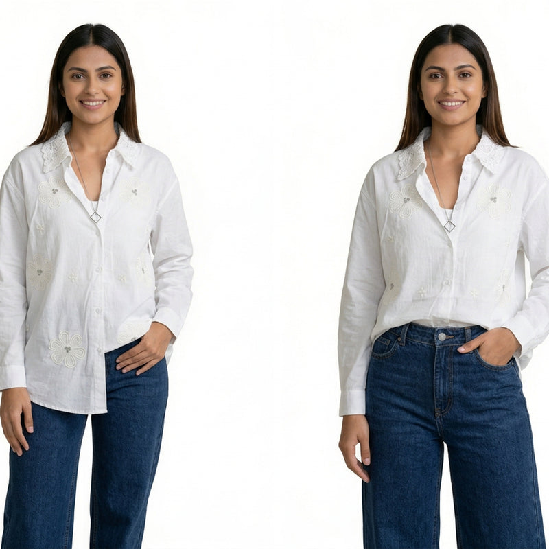 A woman wearing a white button-down shirt with subtle floral embroidery and a textured collar, paired with blue jeans.