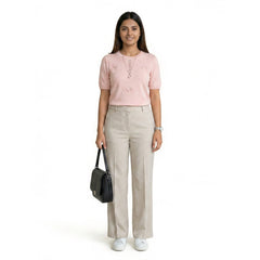 Woman wearing knit co-ord set with short sleeve top and skirt styled with handbag for casual chic outfit