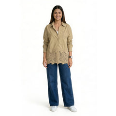 Women’s beige pink button-down shirt with lace hem detailing, long sleeves, and a relaxed fit, styled with blue wide-leg jeans and white sneakers.