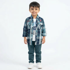 Boy dressed in a teal checked shirt, white graphic t-shirt, green cargo pants, and white sneakers in a studio photoshoot