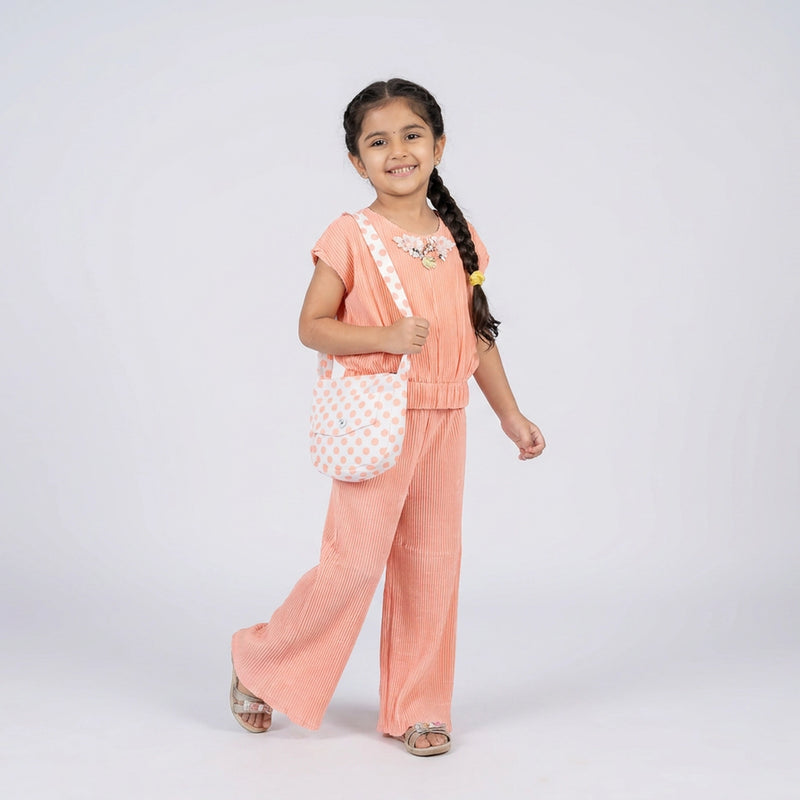 Girl wearing peach ribbed co-ord set with wide leg pants and polka dot sling bag stylish casual outfit for kids