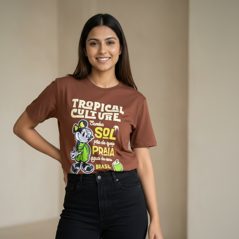 Woman wearing a brown t-shirt with colorful graphics and text against a plain background