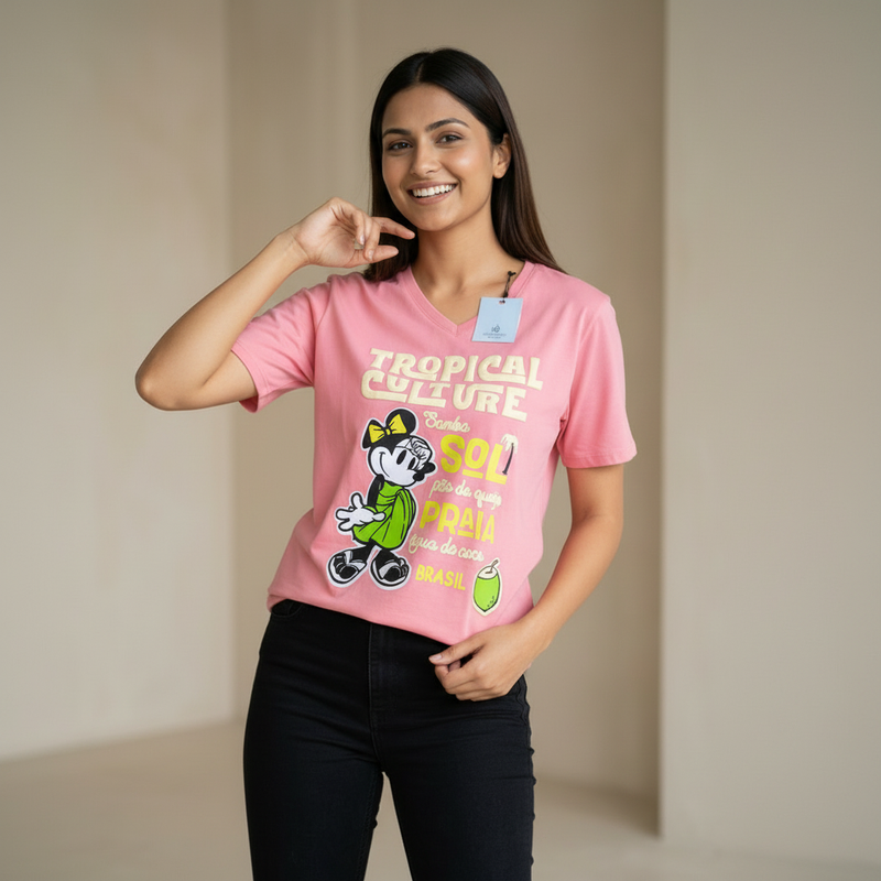Woman wearing a baby pink t-shirt with a graphic design and text, standing against a plain background.