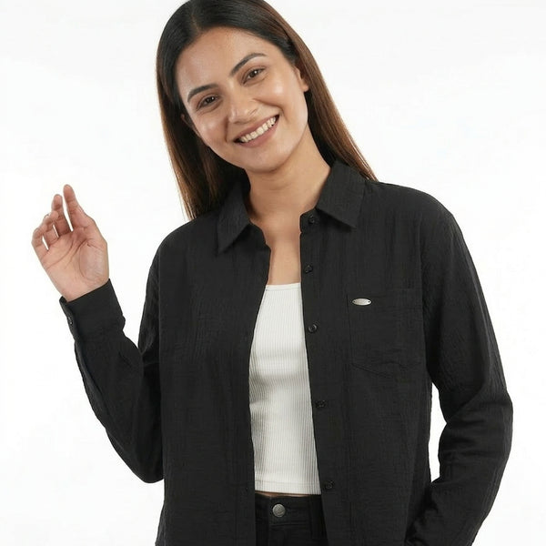 Woman wearing a black shirt over a white shirt on a white background
