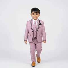 Young boy wearing a pink suit with a white shirt and brown shoes on a white background