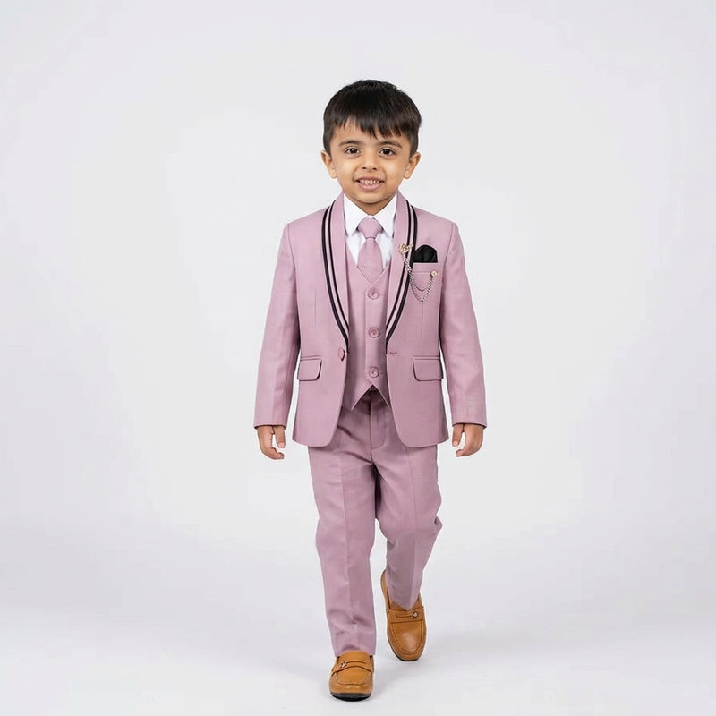 Young boy wearing a pink suit with a white shirt and brown shoes on a white background
