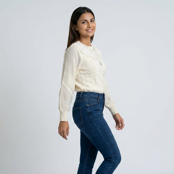 Woman wearing knit sweater with lace collar and long sleeves paired with blue jeans casual winter outfit