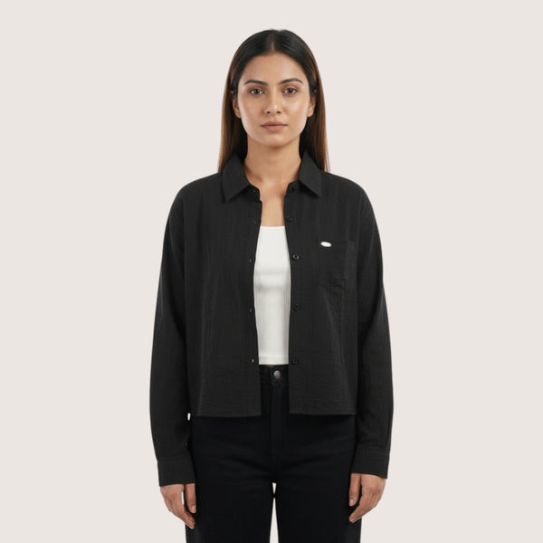 Woman wearing a black shirt over a white shirt on a white background
