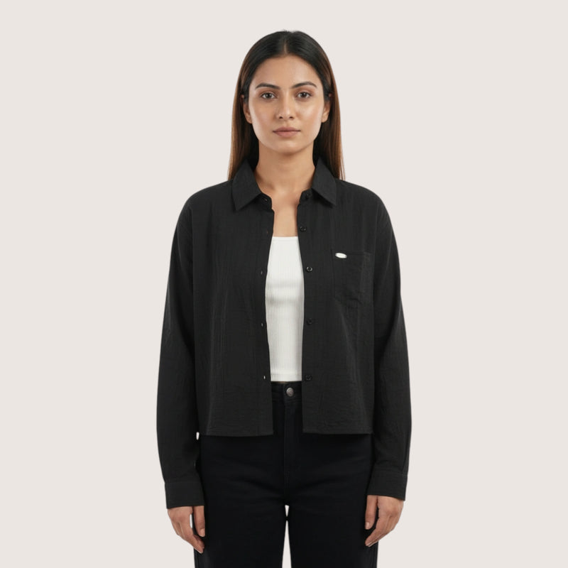 Woman wearing a black shirt over a white shirt on a white background